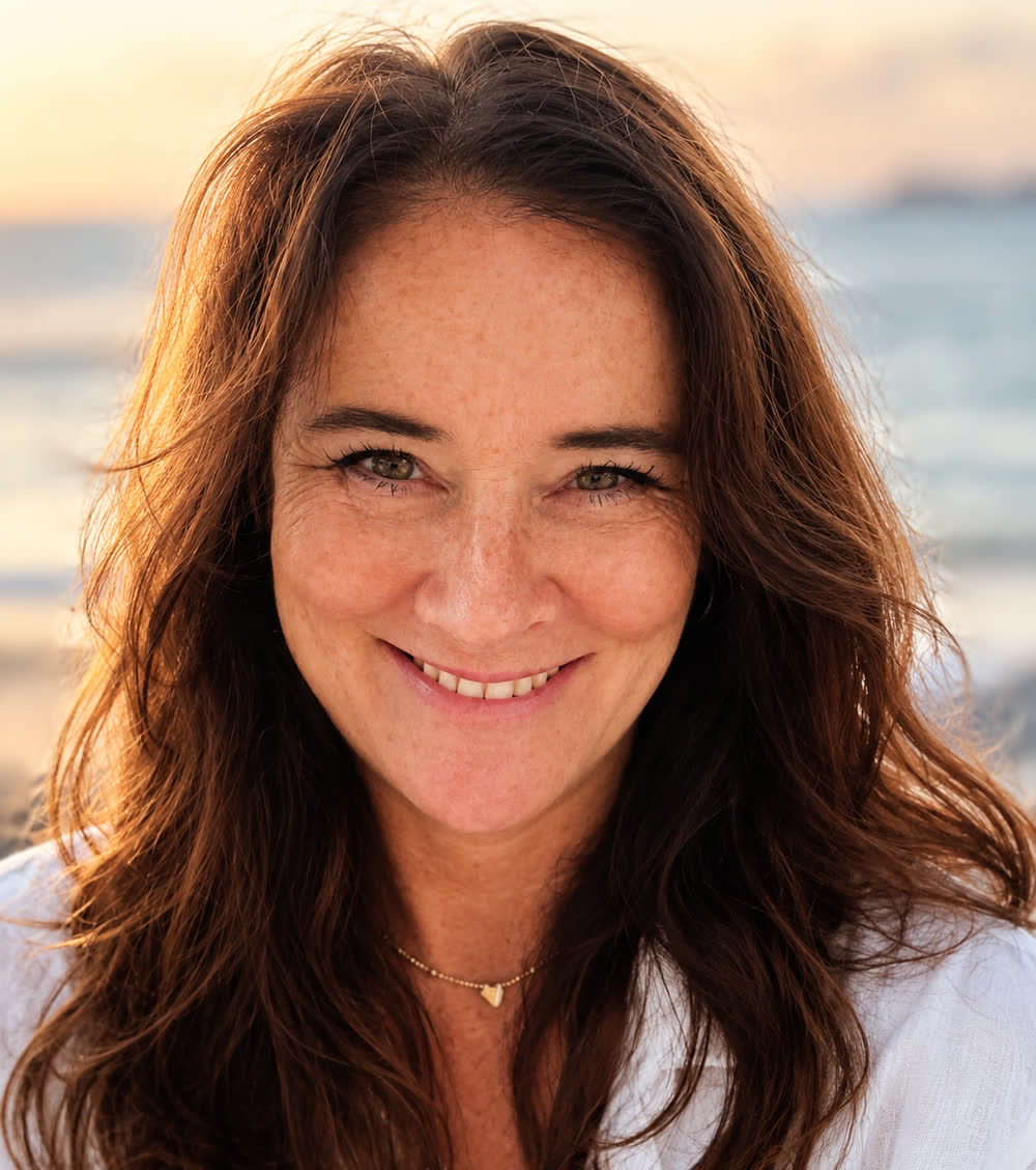 Britta Karres, lächelnd, am Meer im Abendlicht